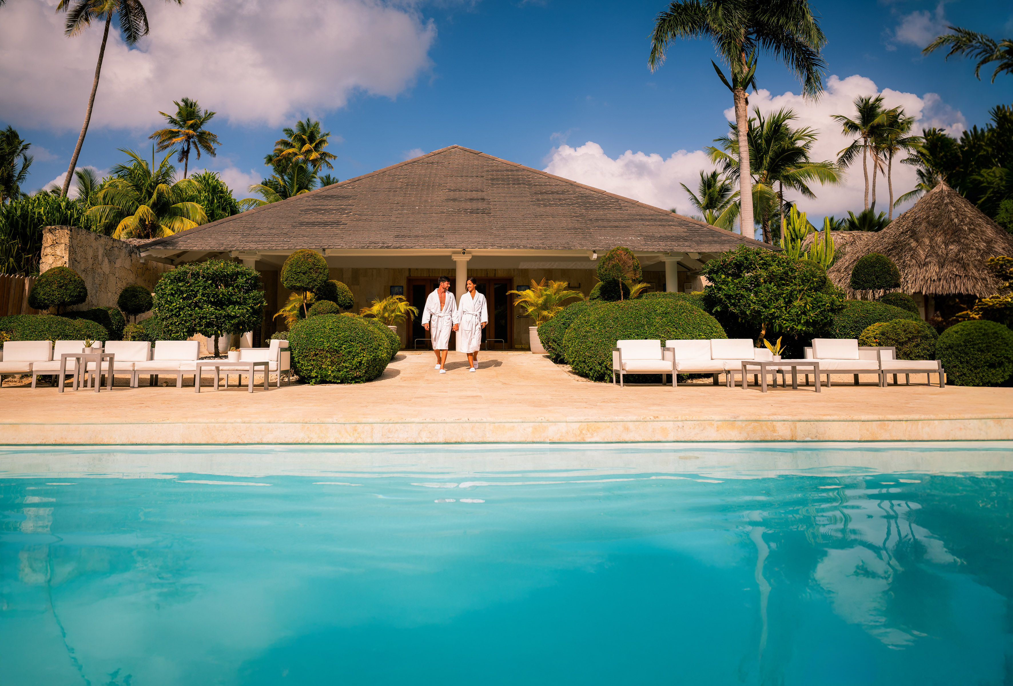 two people standing in front of a pool