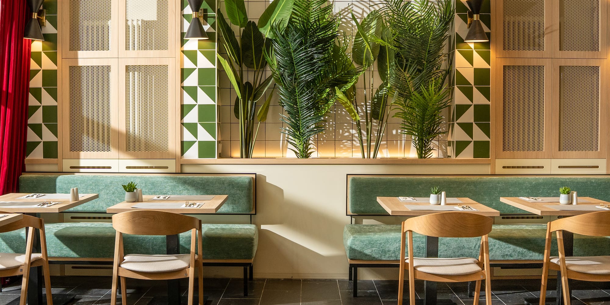 a room with green and white tiles and tables and chairs