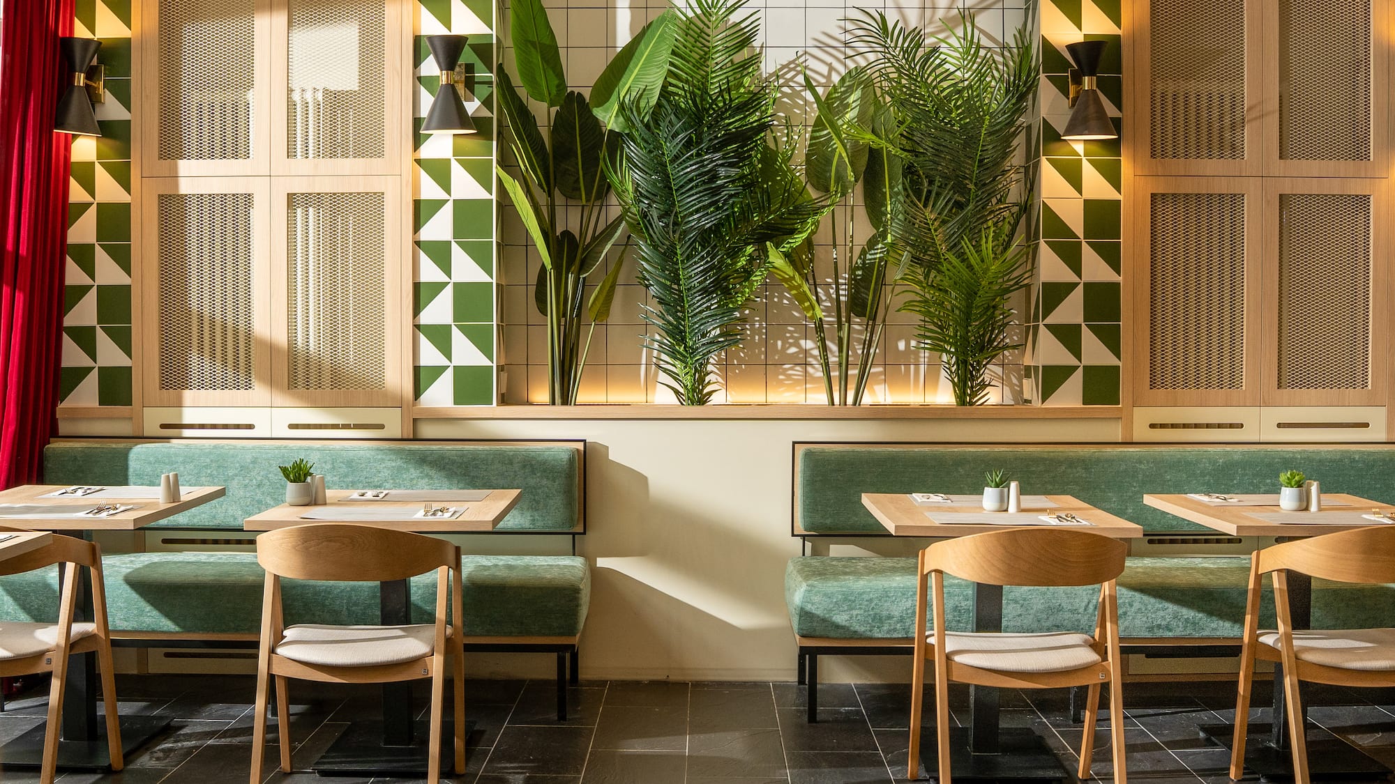 a room with green and white tiles and tables and chairs