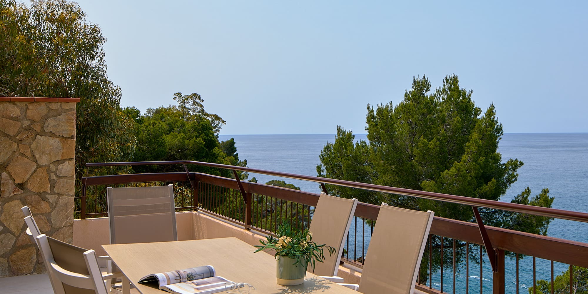 a table and chairs on a balcony overlooking the ocean
