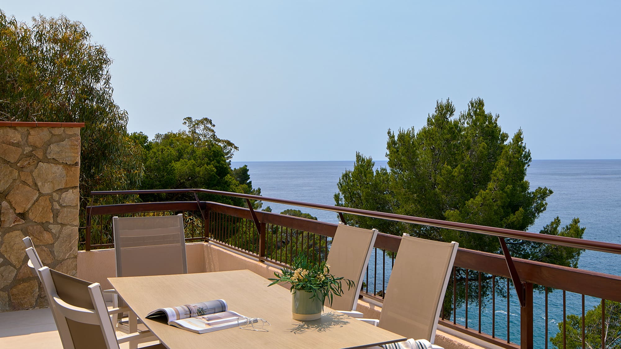 a table and chairs on a balcony overlooking the ocean