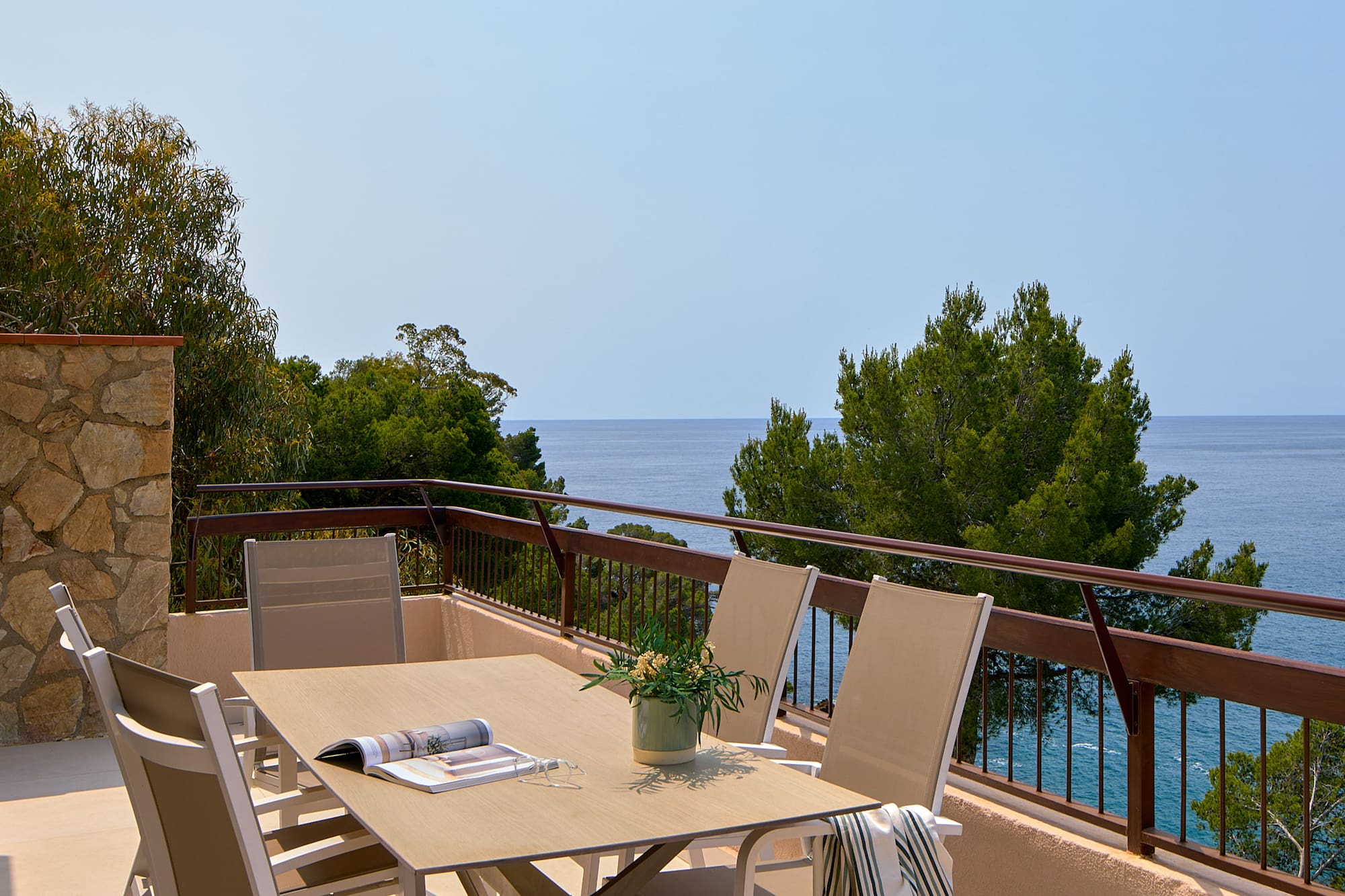 a table and chairs on a balcony overlooking the ocean