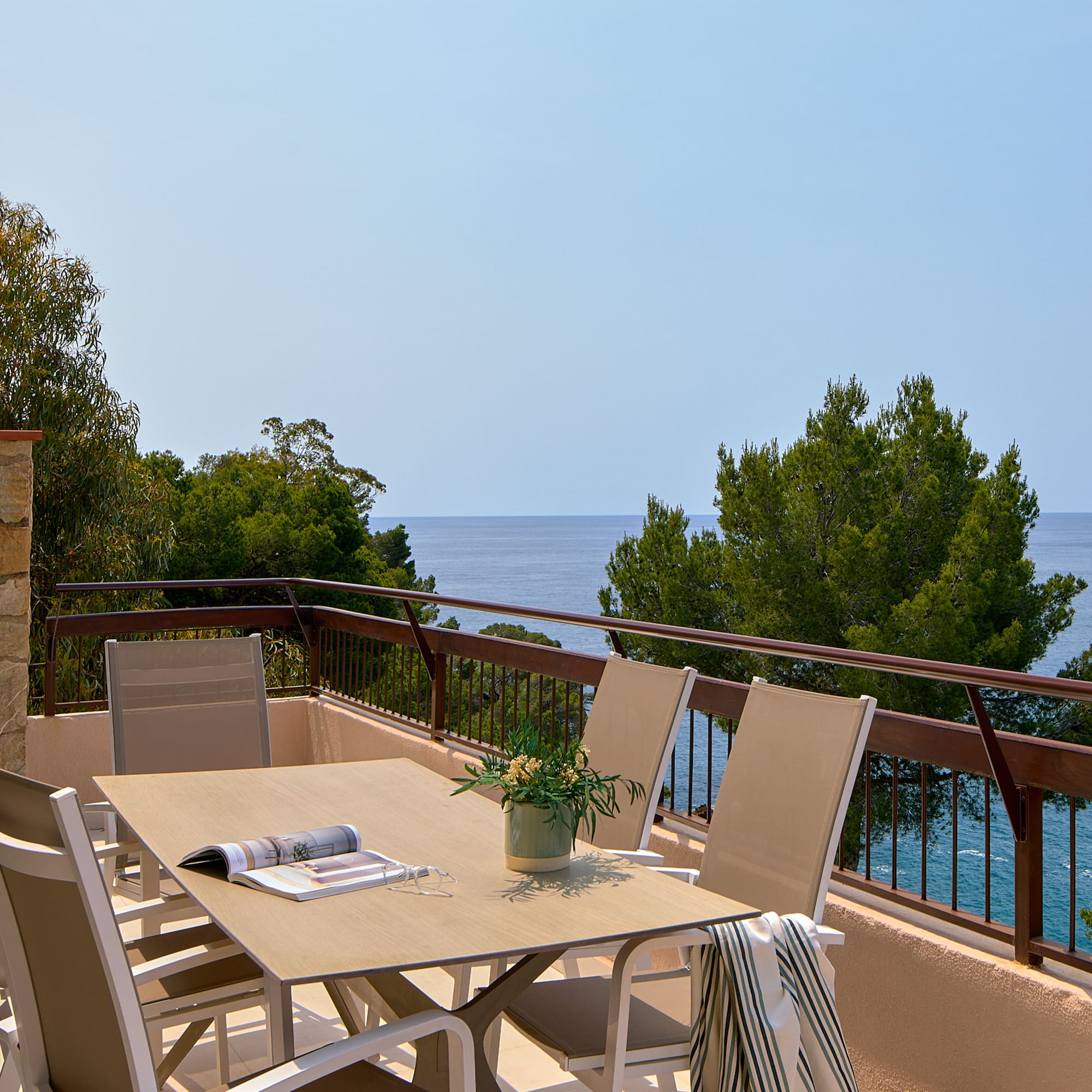a table and chairs on a balcony overlooking the ocean