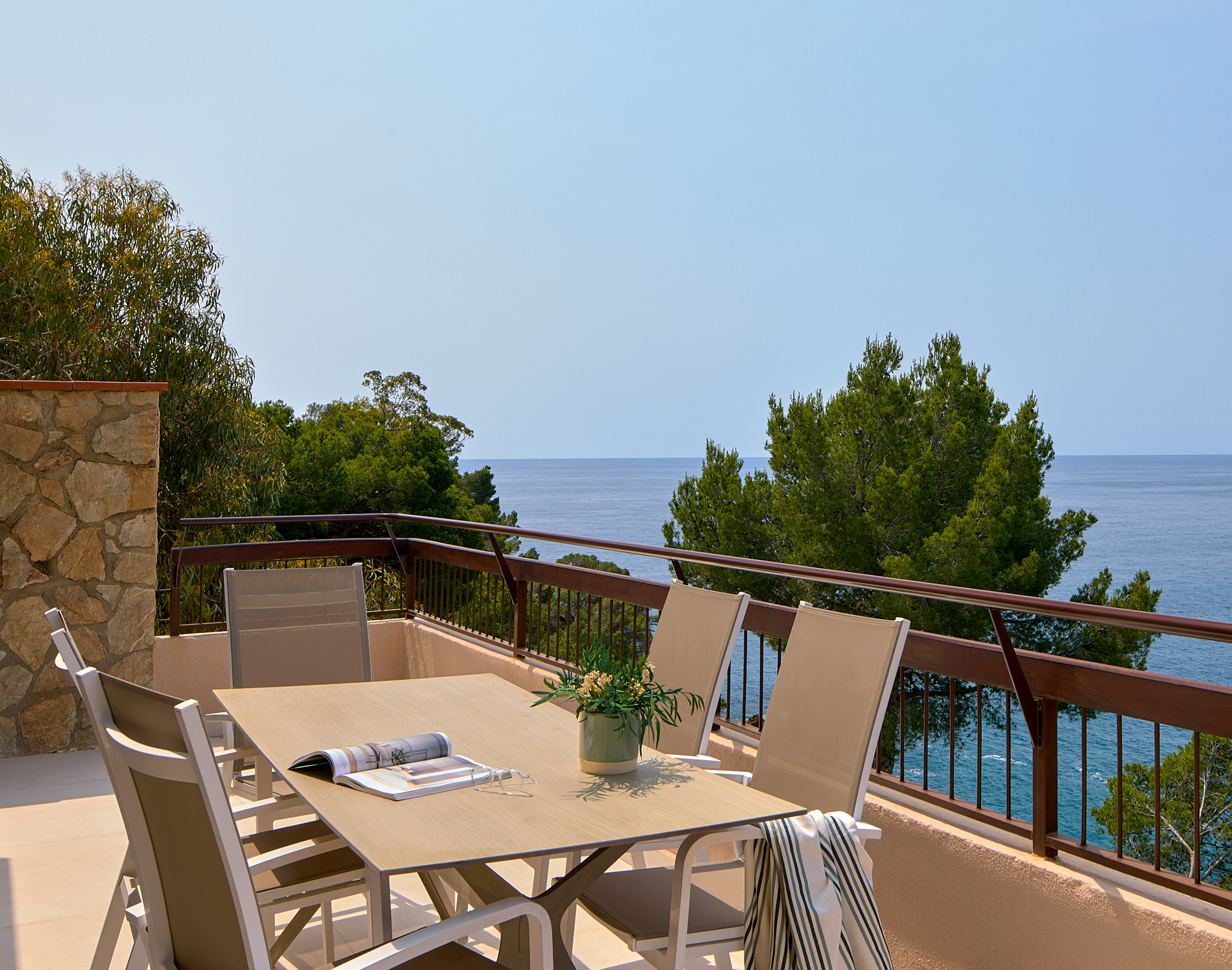 a table and chairs on a balcony overlooking the ocean
