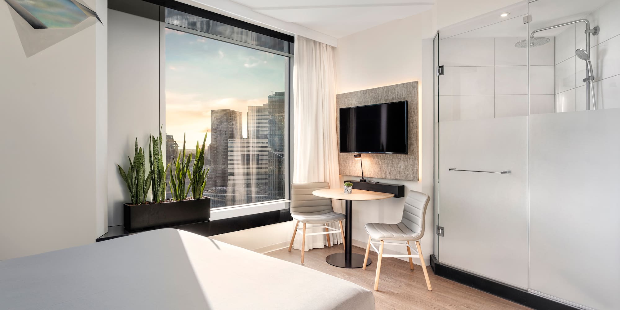 a room with a bed and a table and a tv