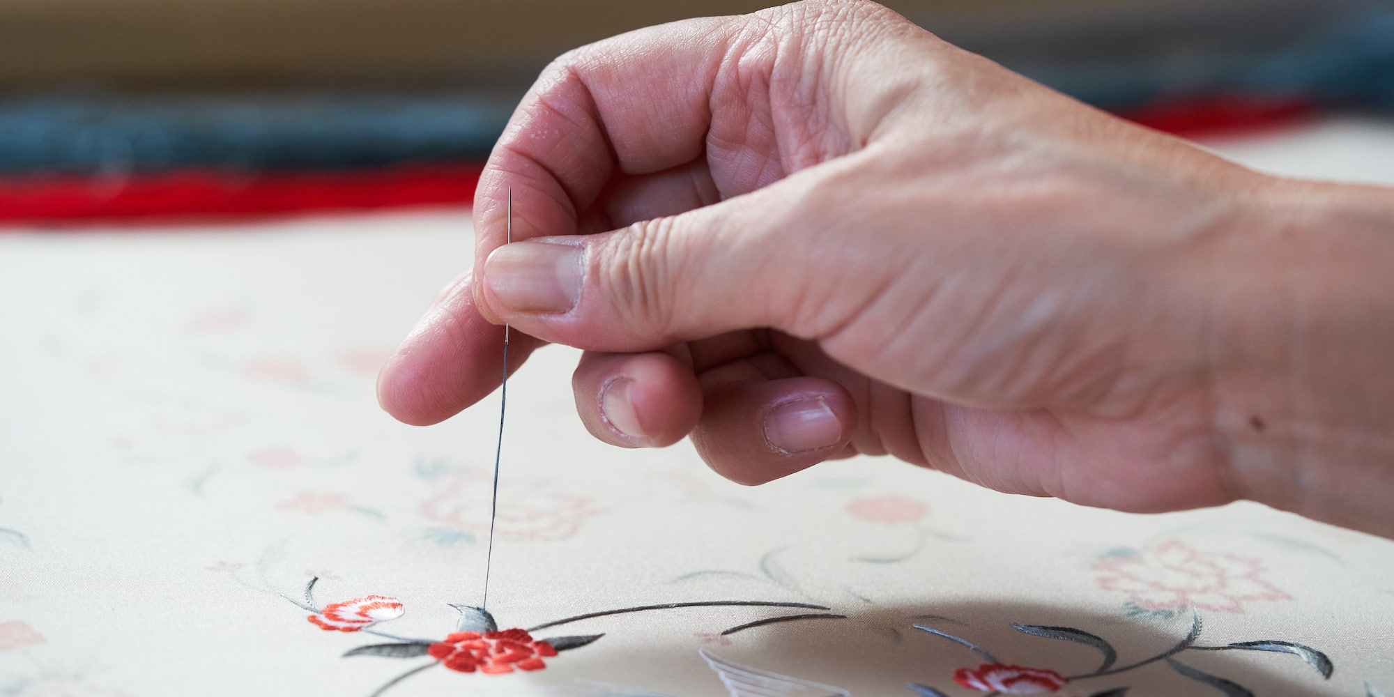 a person sewing a flower design