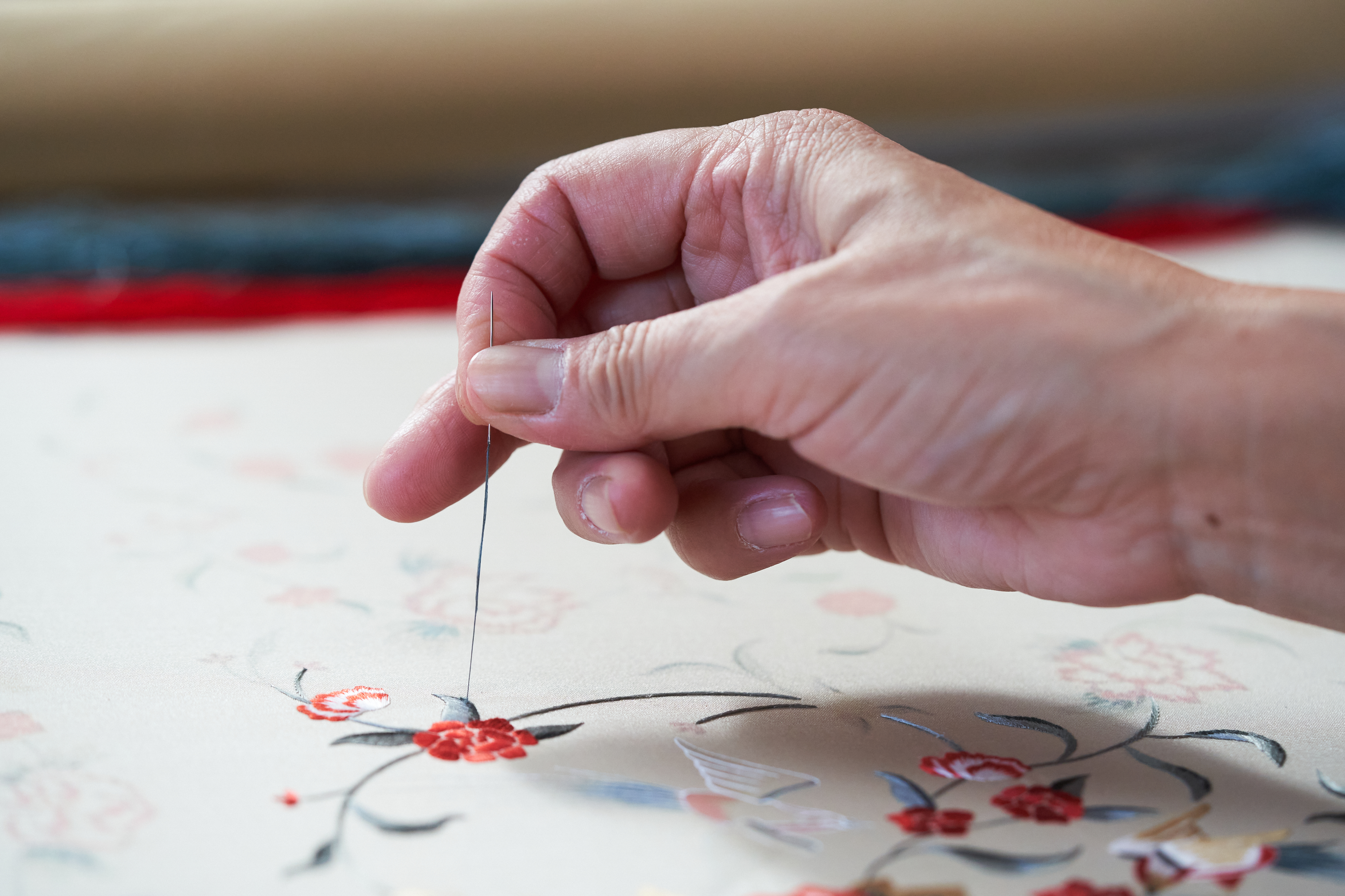a person sewing a flower design