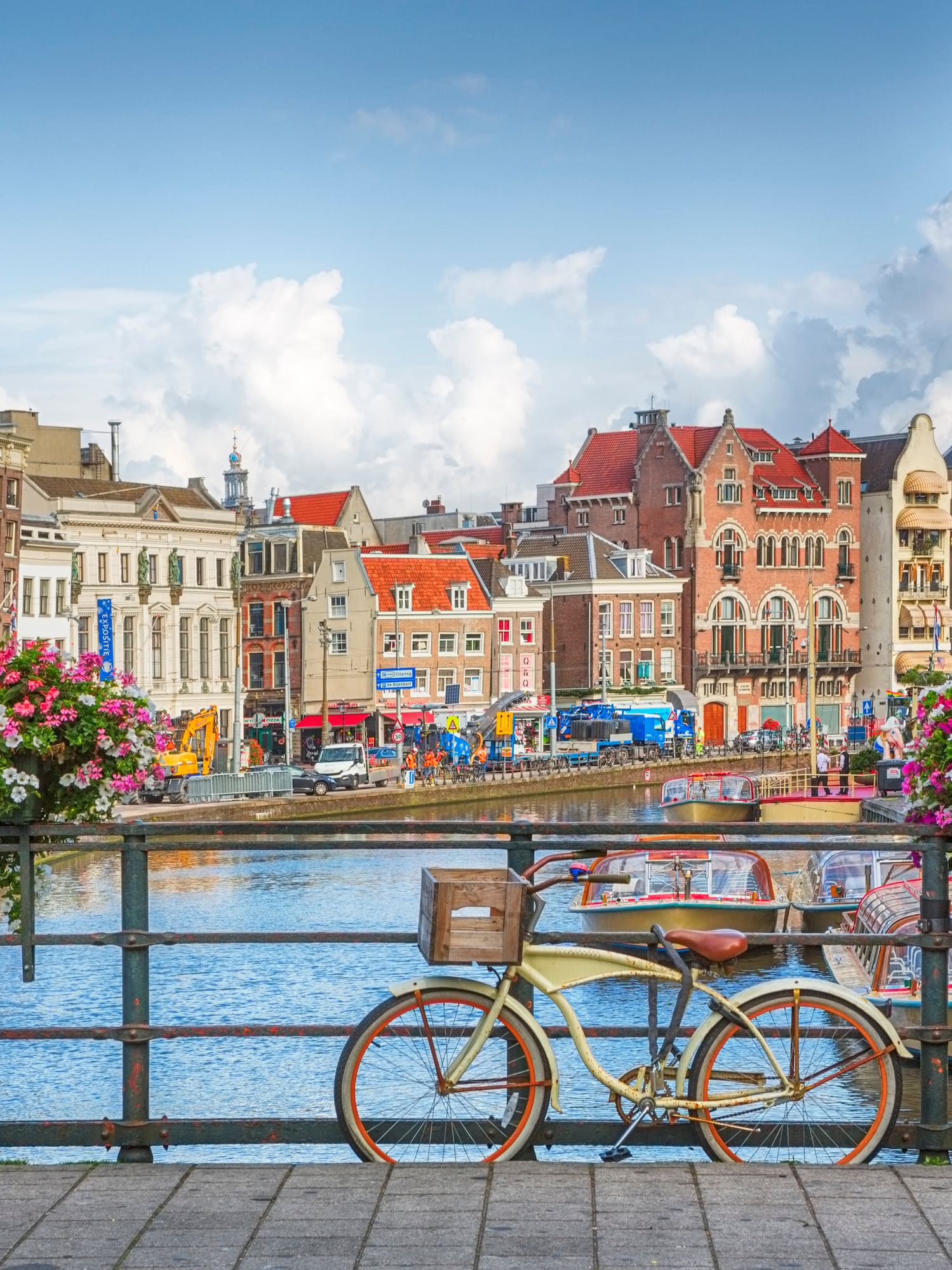 a bicycle on a bridge over a canal with flowers