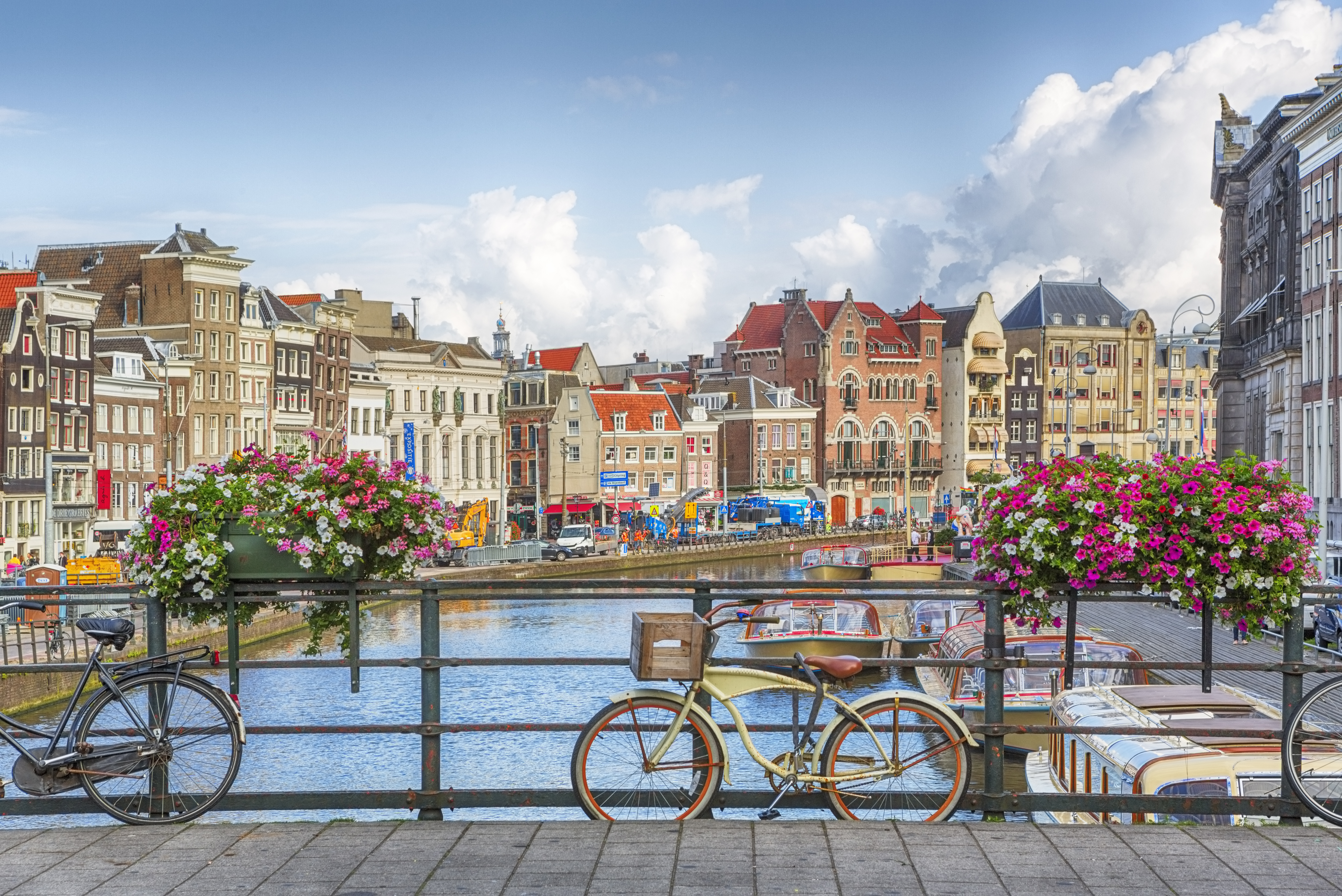 a bicycle on a bridge over a canal with flowers