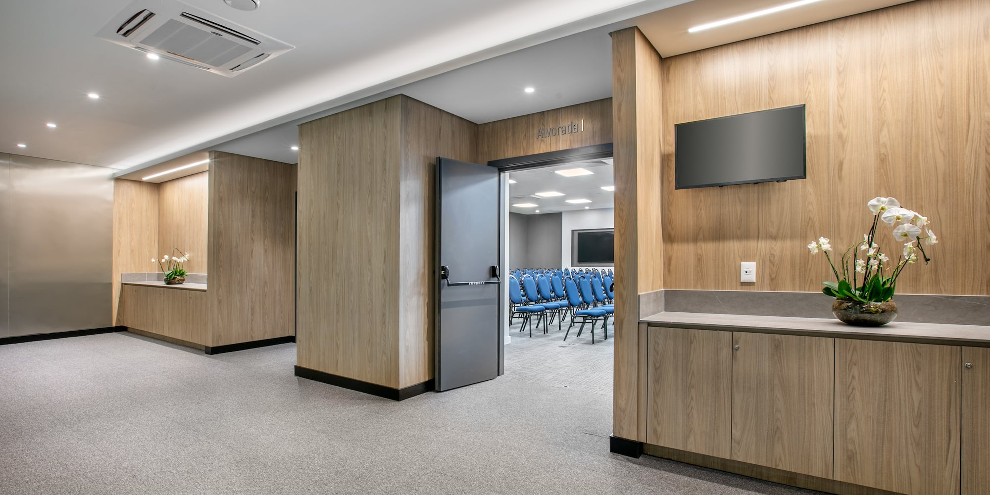 a room with a door open and chairs in the background