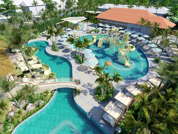 a pool with water slides and chairs and trees