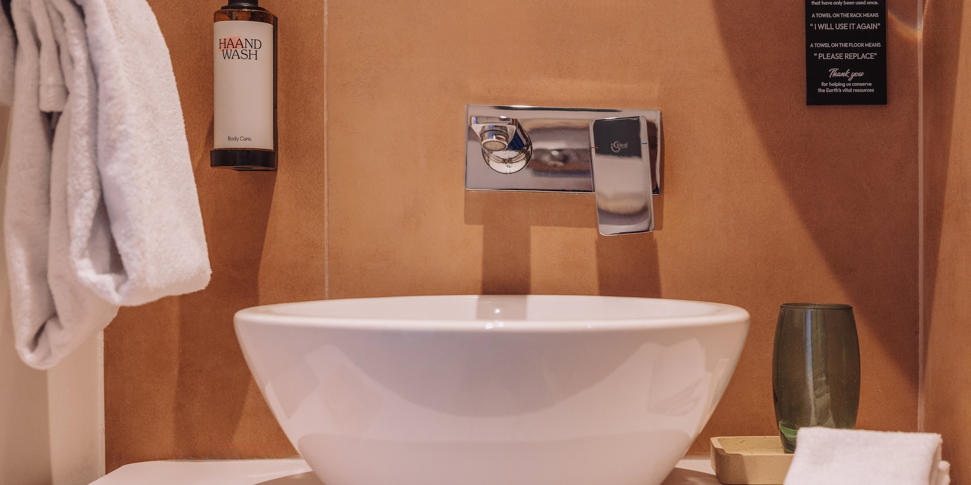 a white sink with a silver faucet and a bottle of soap