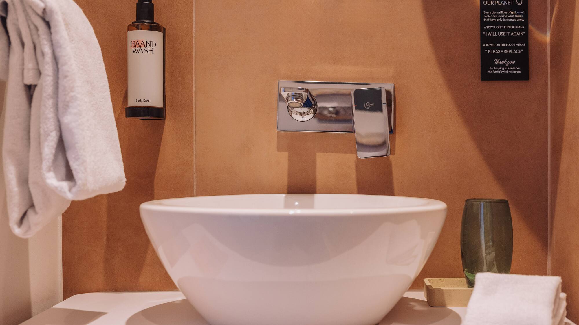 a white sink with a silver faucet and a bottle of soap