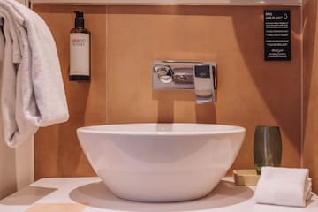 a white sink with a silver faucet and a bottle of soap