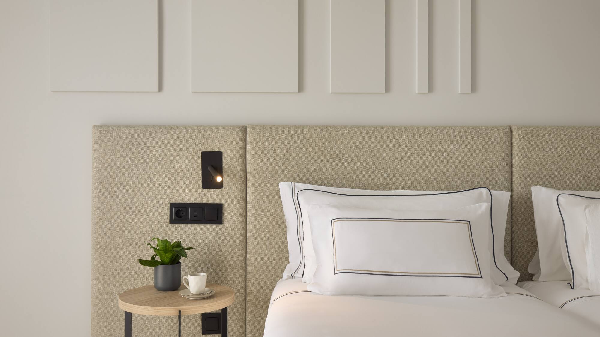 a bed with a plant on a table