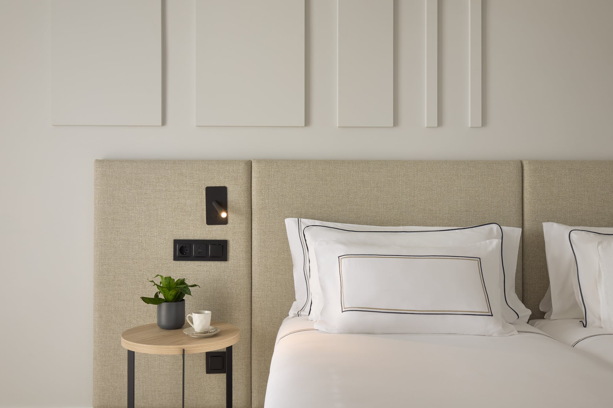 a bed with a plant on a table