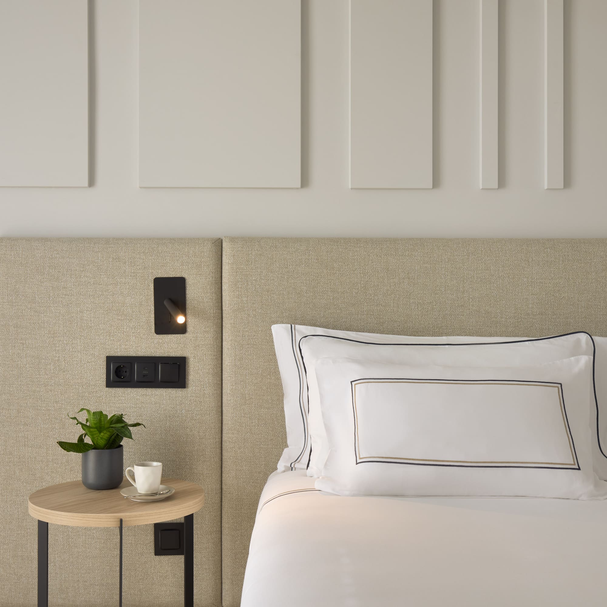 a bed with a plant on a table