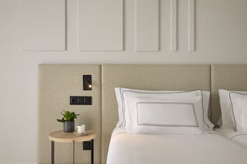 a bed with a plant on a table