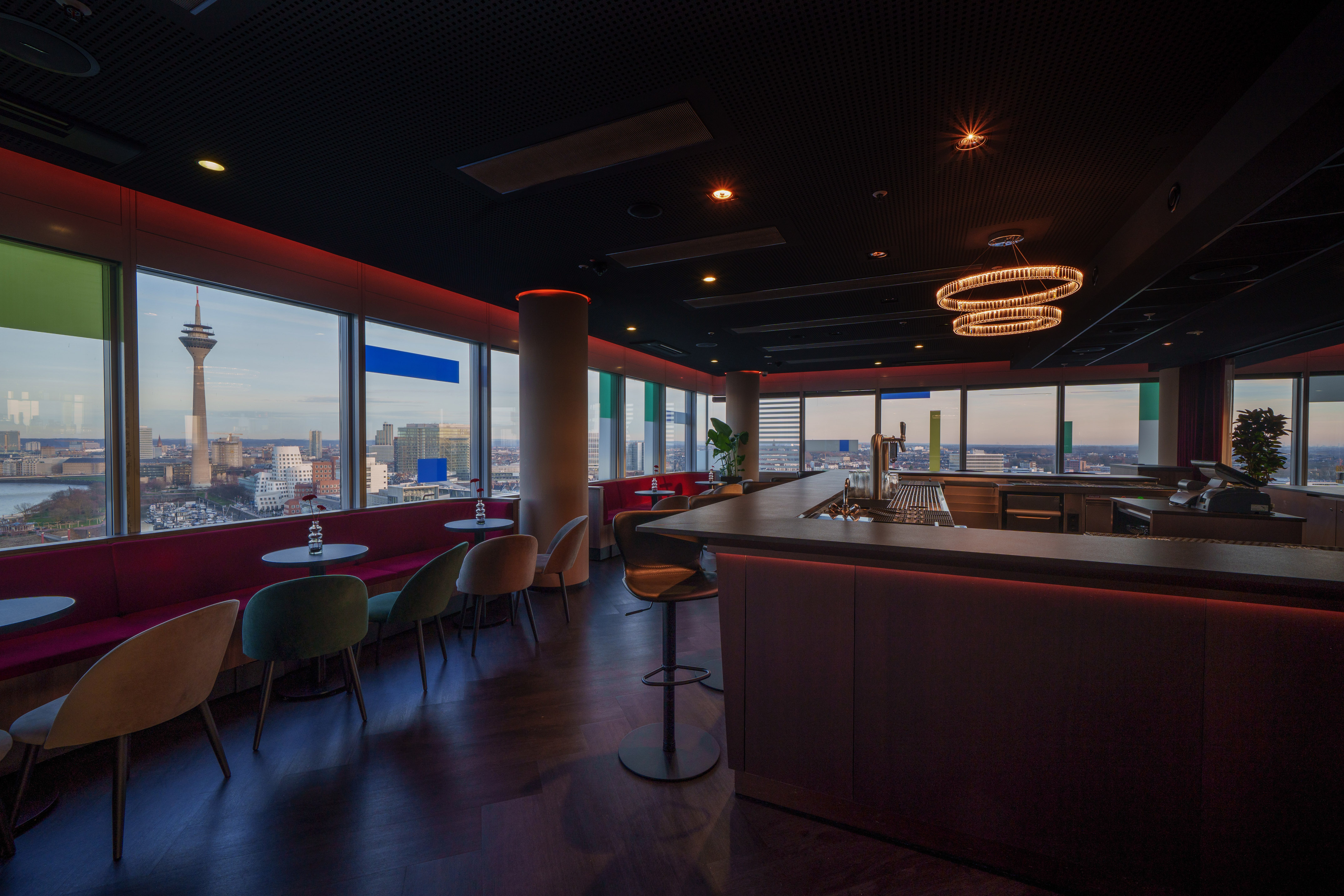 Modern bar with panoramic Düsseldorf cityscape, featuring Rheinturm.