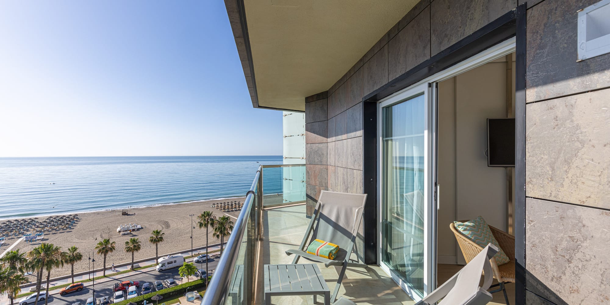 Ocean view balcony with lounge chairs, beach, and swimming pool.