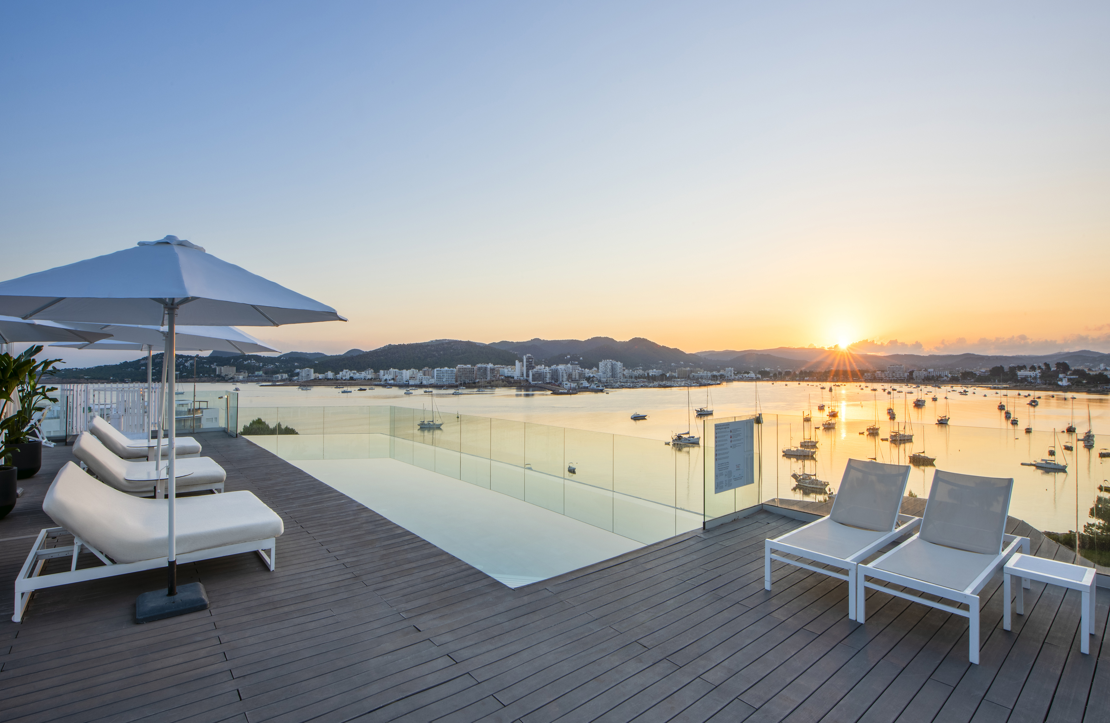 a deck with chairs and a pool overlooking a body of water