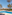 Tropical resort pool with palm trees, sun loungers, and colorful buildings.
