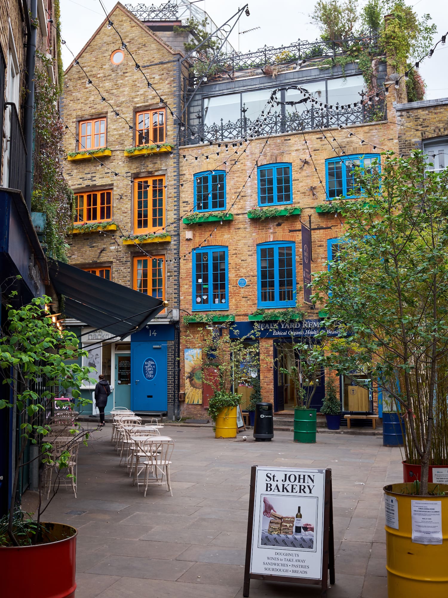 a courtyard with chairs and trees in front of a building