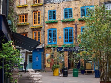 a courtyard with chairs and trees in front of a building