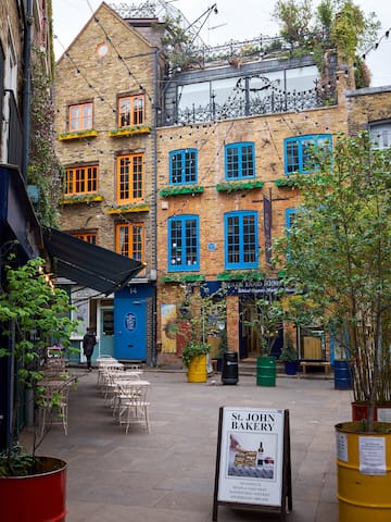 a courtyard with chairs and trees in front of a building