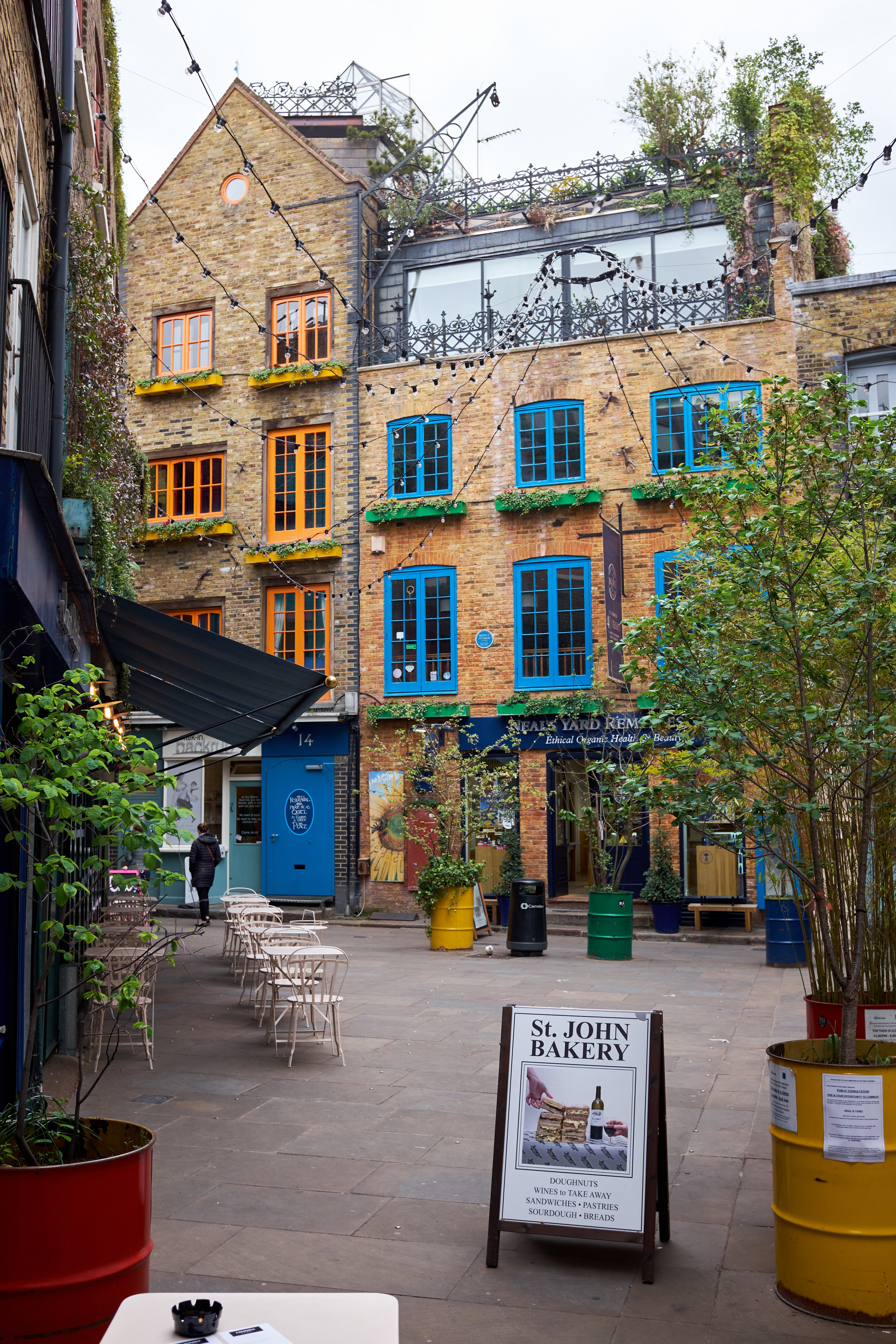 a courtyard with chairs and trees in front of a building