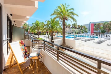 a balcony with palm trees and a pool