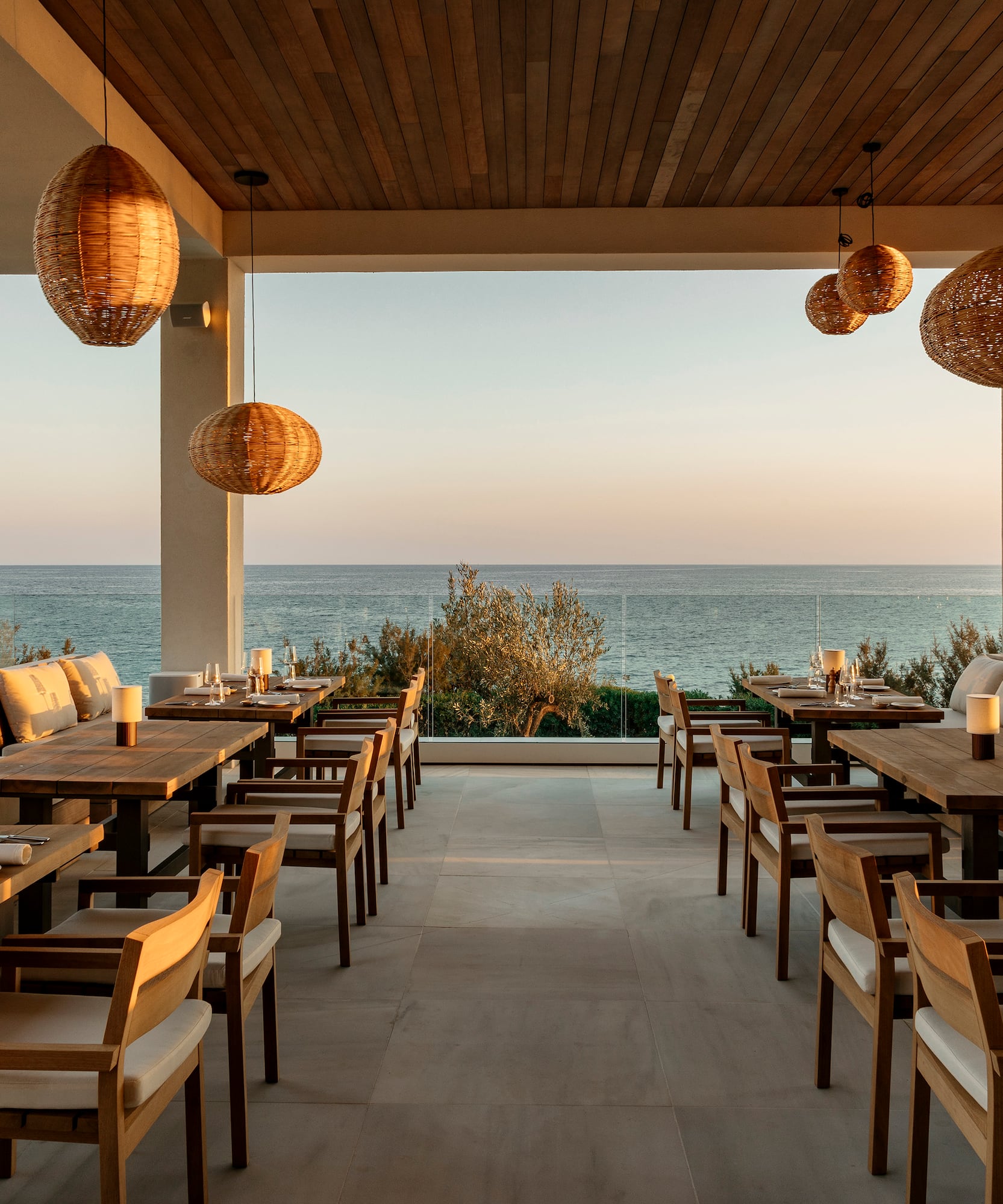 a restaurant with tables and chairs and a view of the ocean