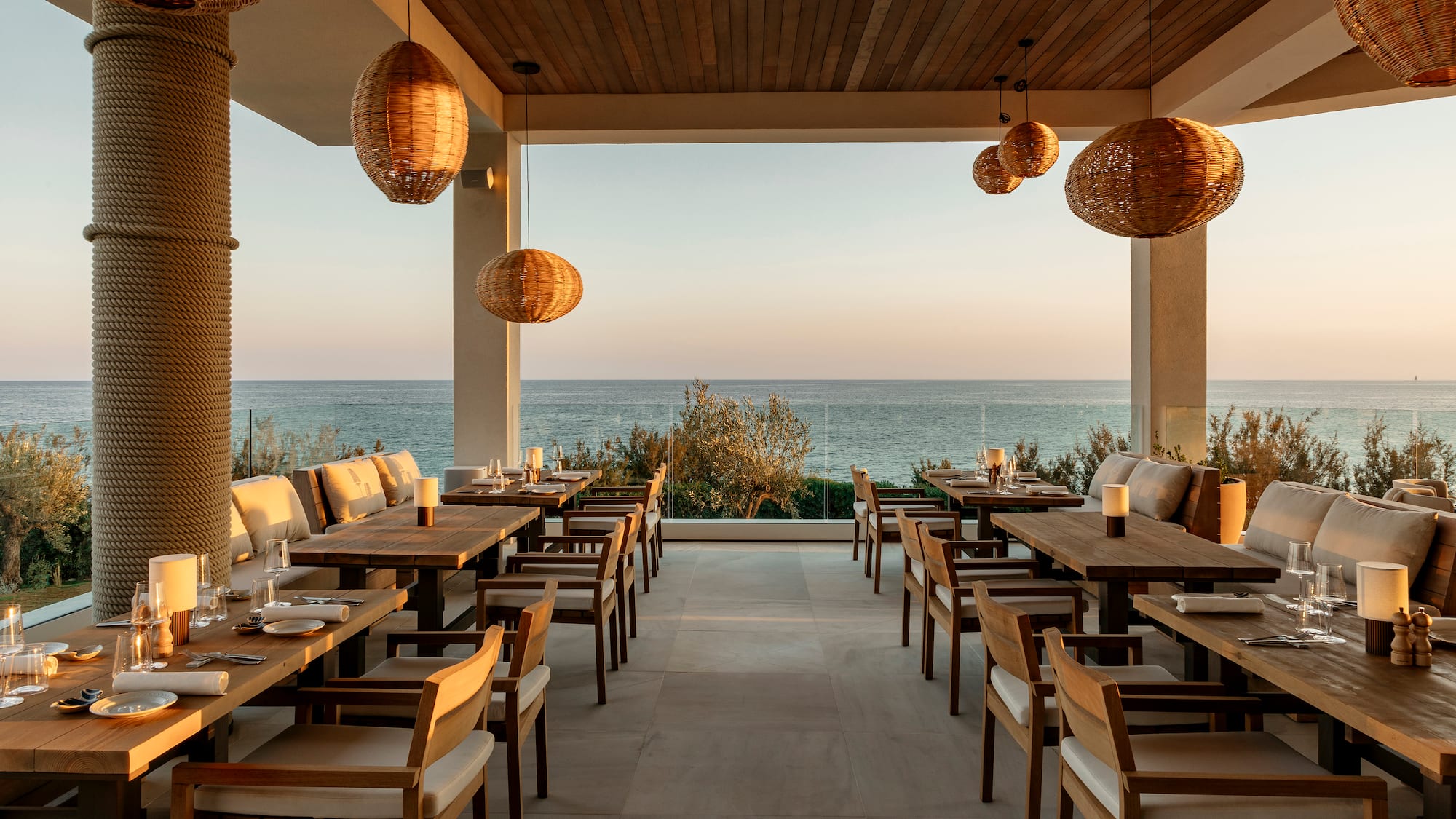 a restaurant with tables and chairs and a view of the ocean