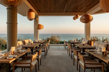 a restaurant with tables and chairs and a view of the ocean