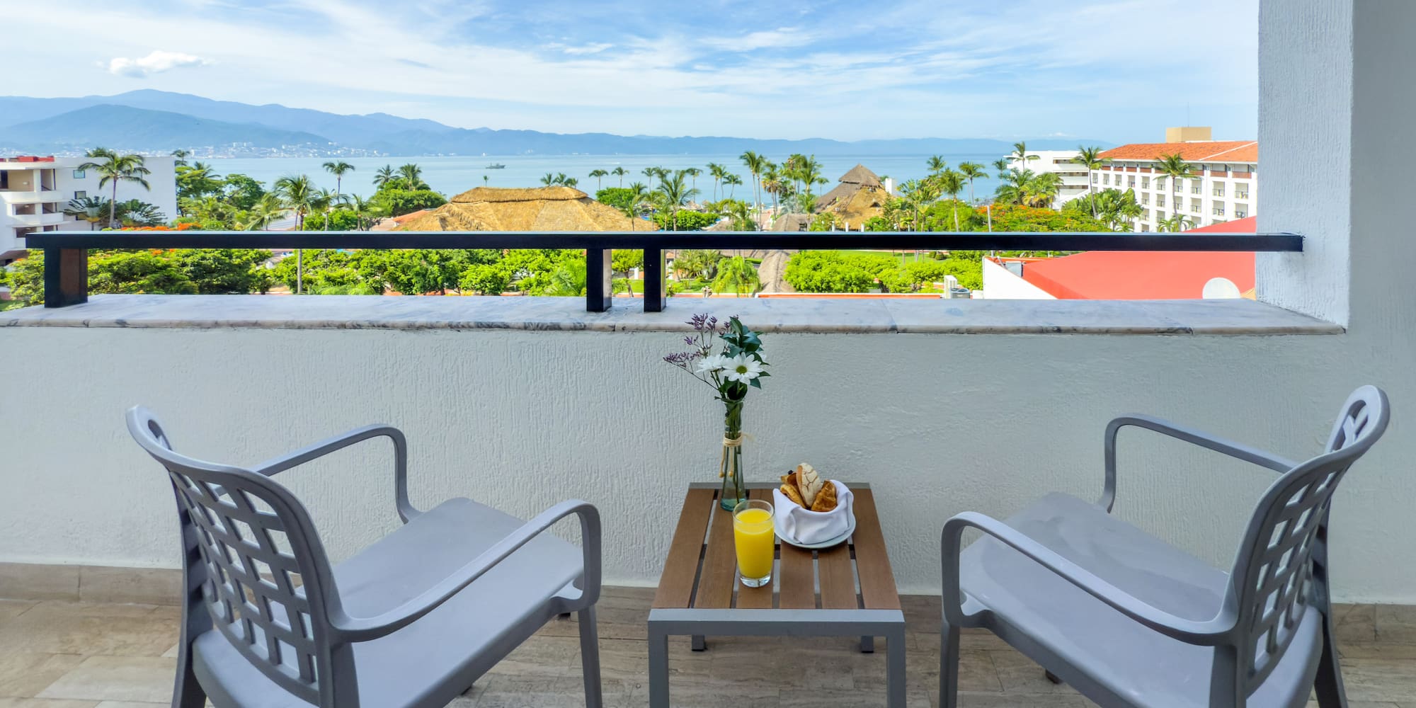 a table and chairs on a balcony overlooking a body of water