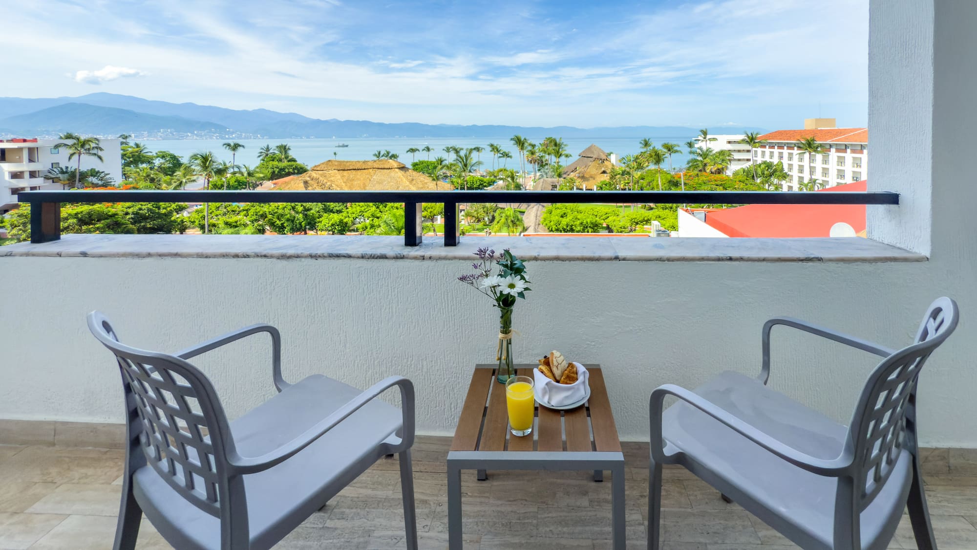 a table and chairs on a balcony overlooking a body of water
