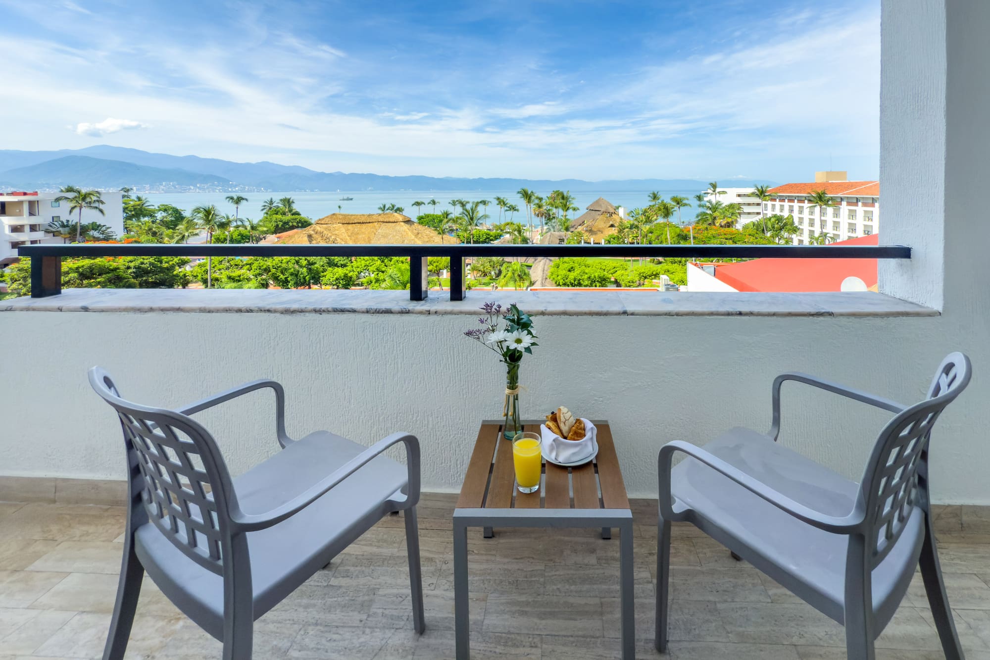 a table and chairs on a balcony overlooking a body of water