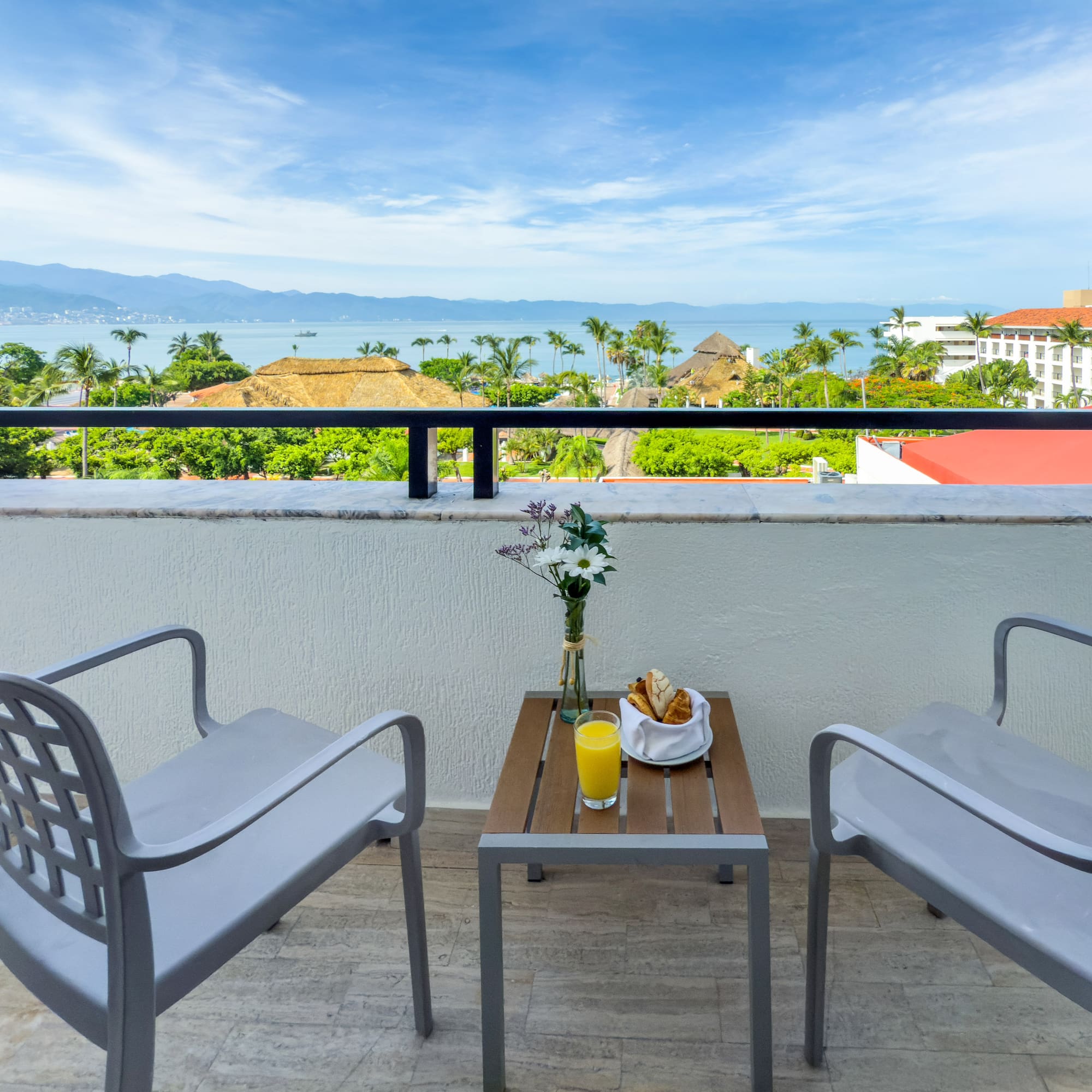 a table and chairs on a balcony overlooking a body of water