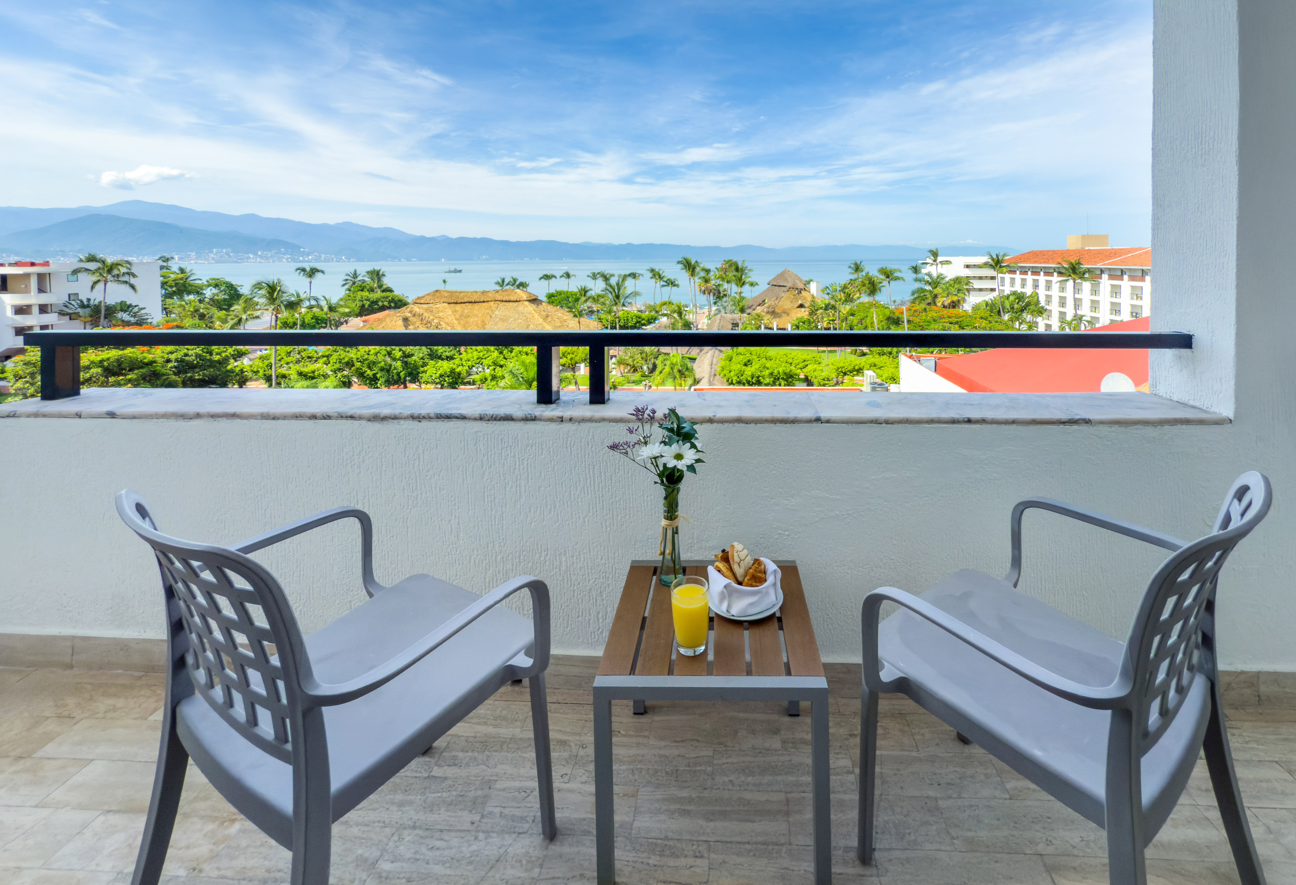 a table and chairs on a balcony overlooking a body of water