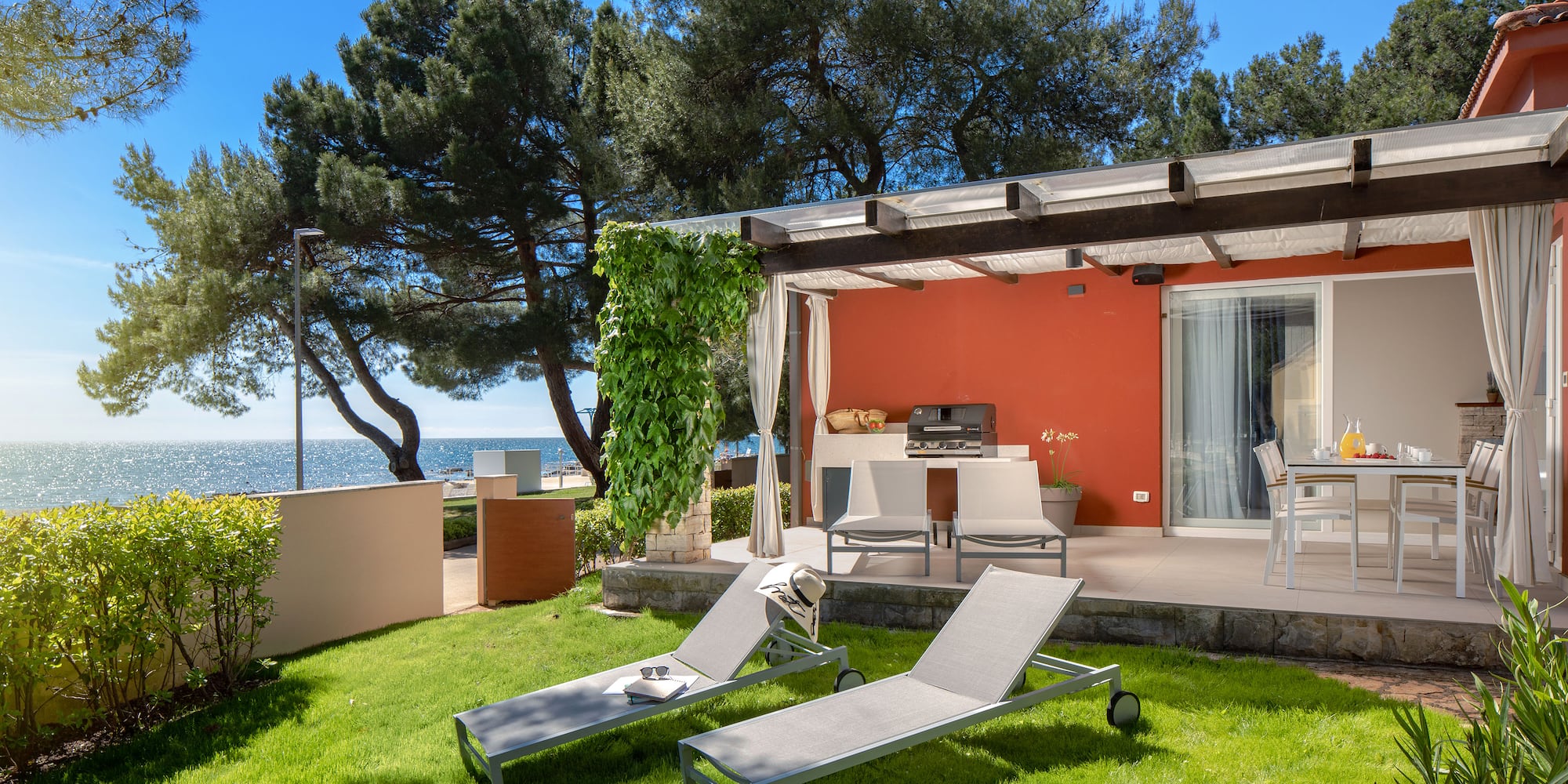 a deck chairs and a grill on a patio by a house