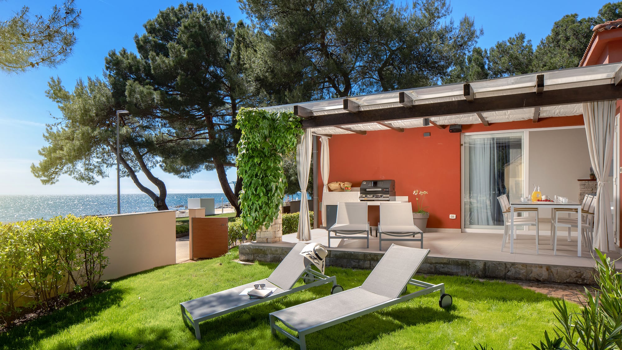 a deck chairs and a grill on a patio by a house
