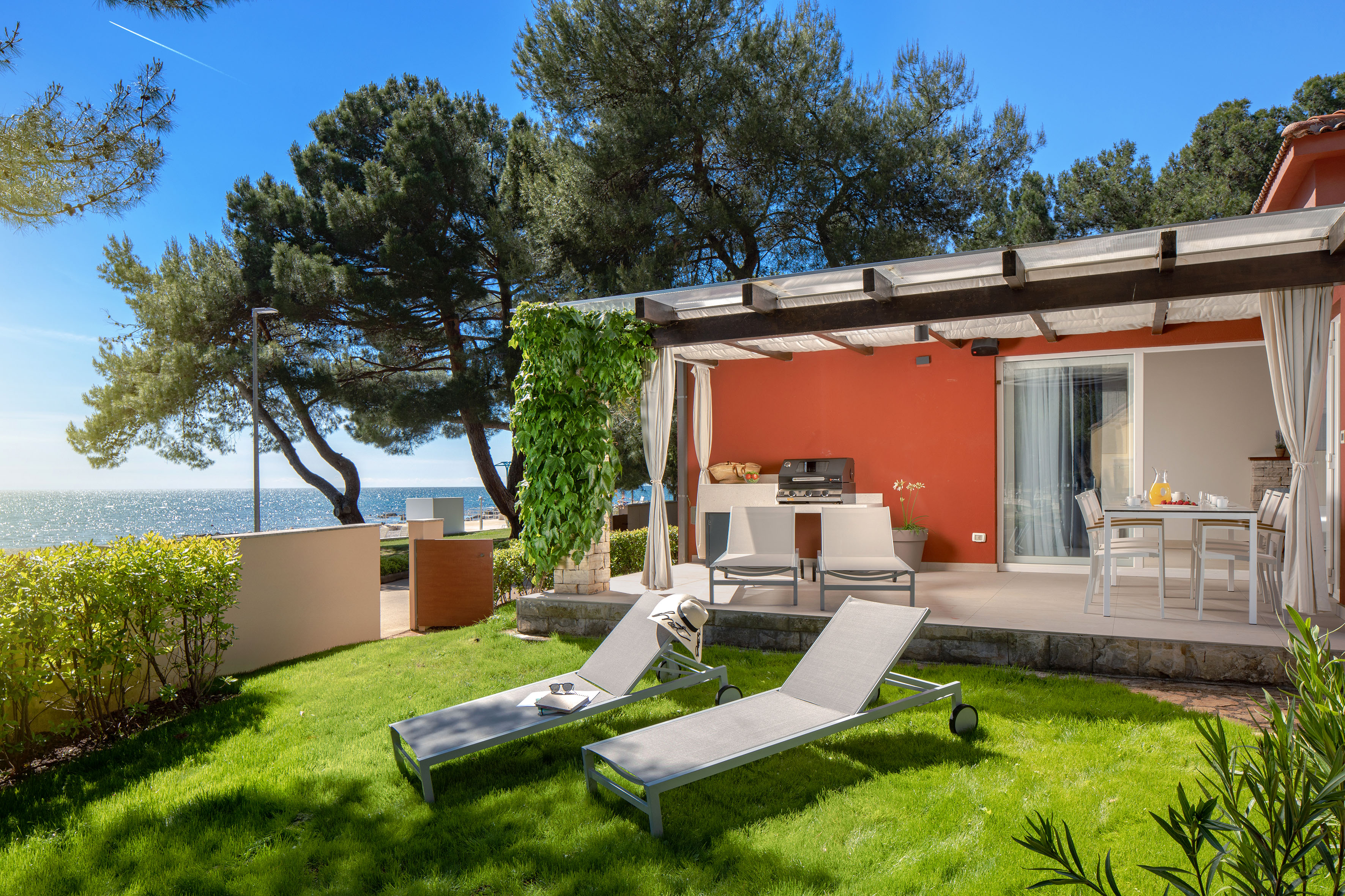 a deck chairs and a grill on a patio by a house