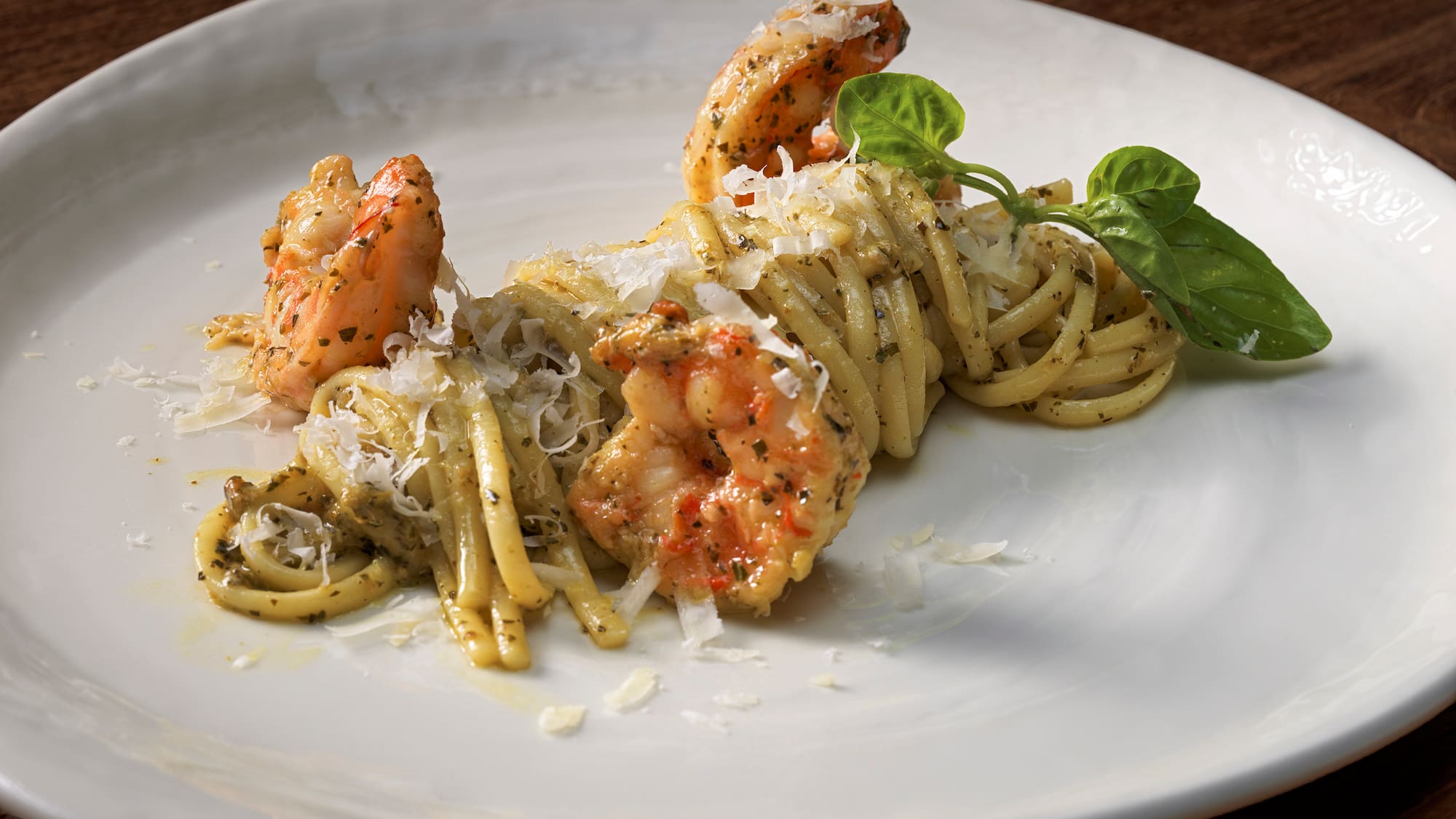 a plate of pasta with shrimp and basil