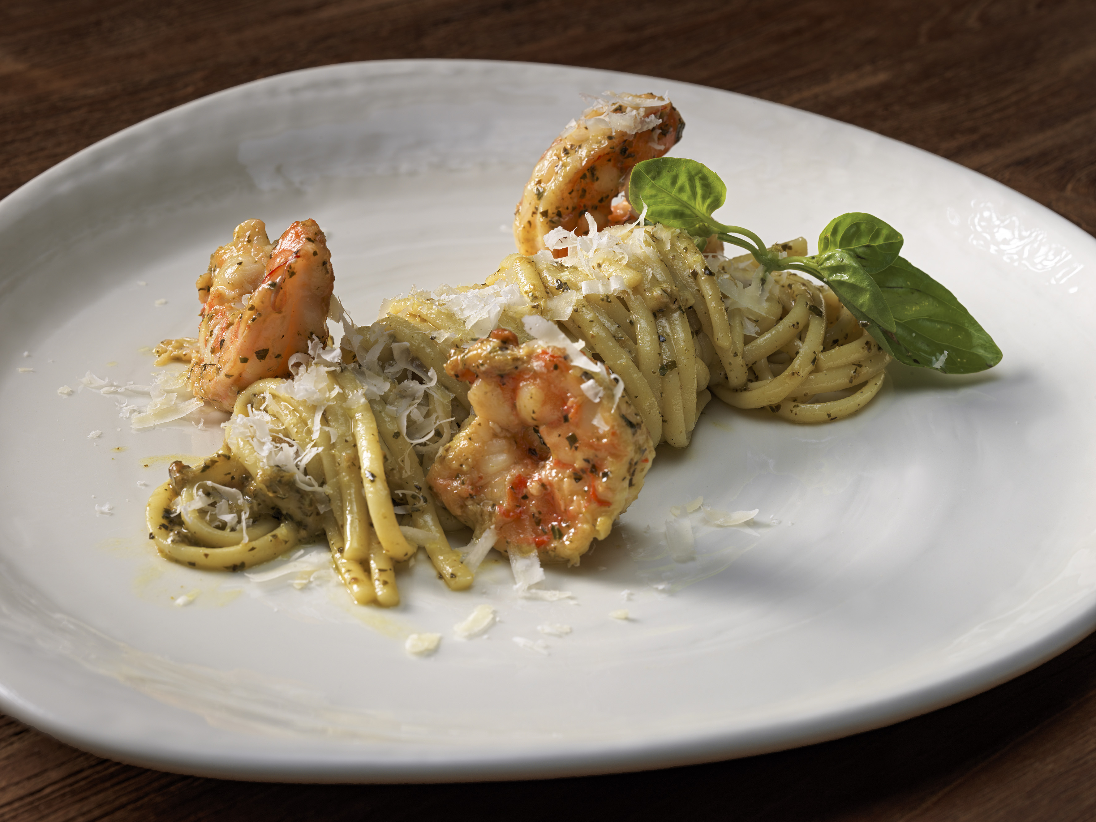 a plate of pasta with shrimp and basil
