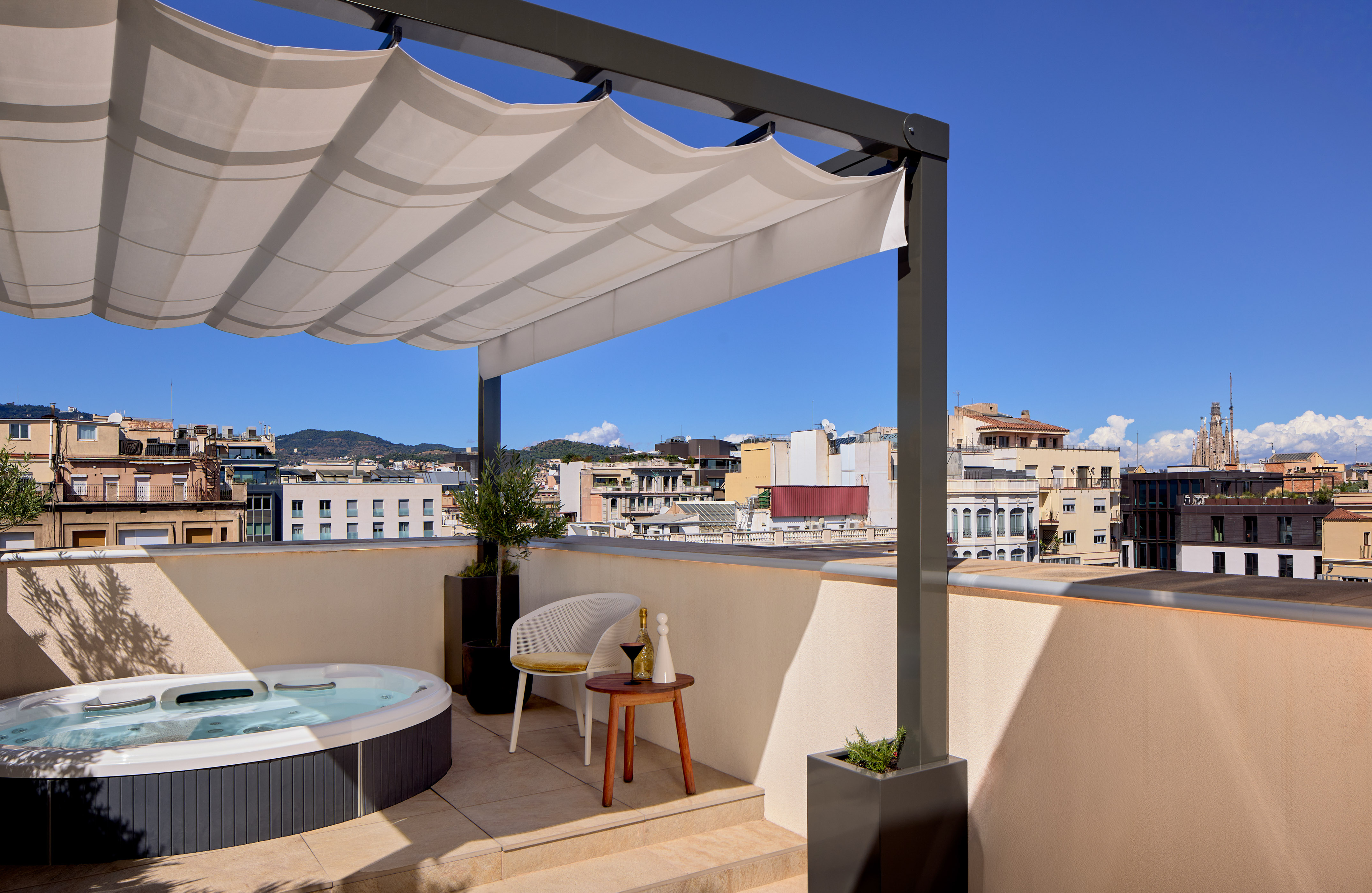 Rooftop terrace with hot tub, retractable pergola, and city view.