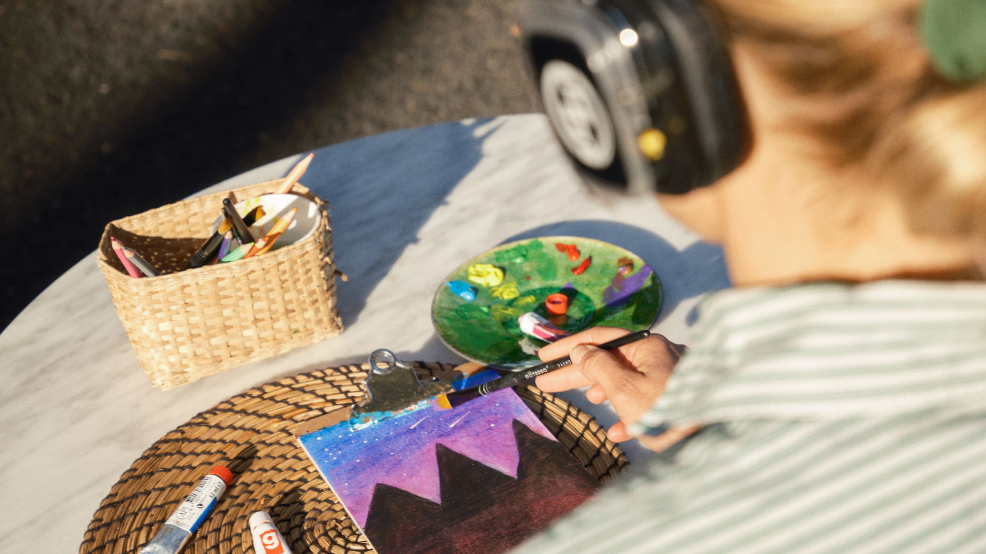 a woman wearing headphones painting on a table