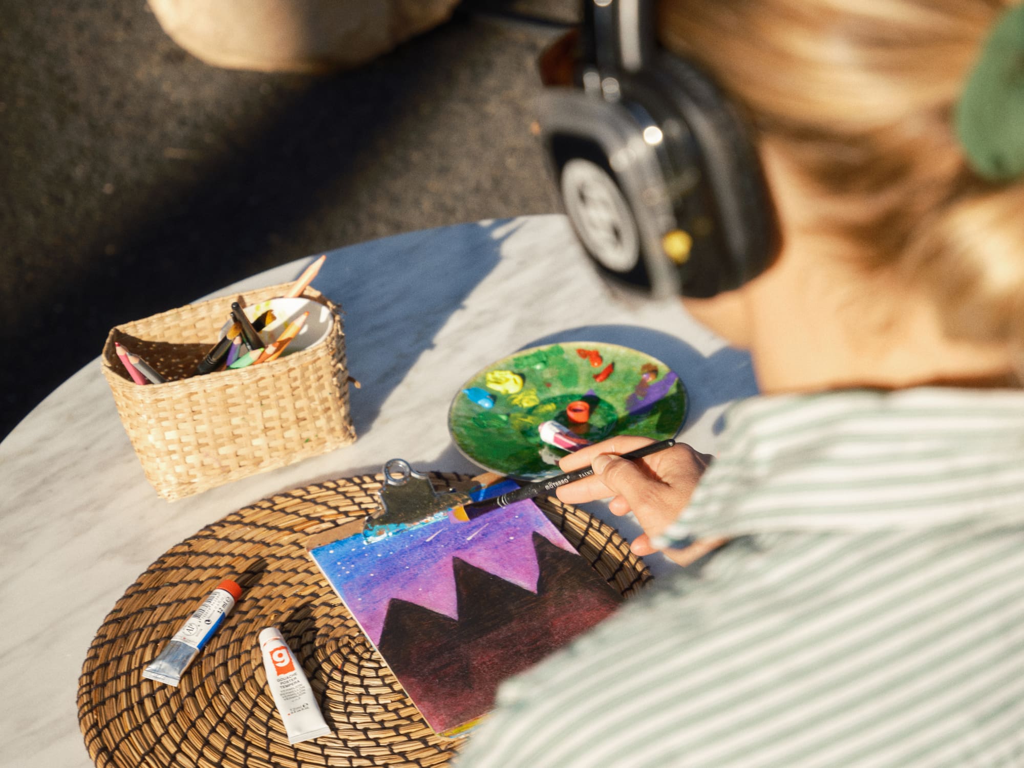 a woman wearing headphones painting on a table