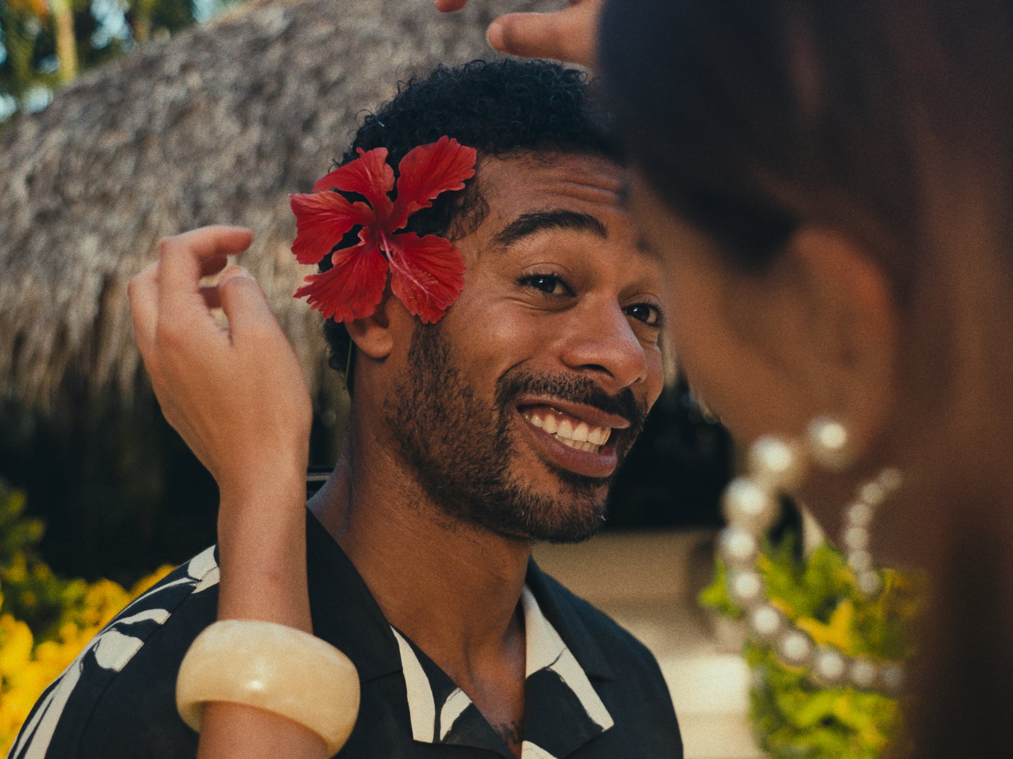 a man with a flower on his ear