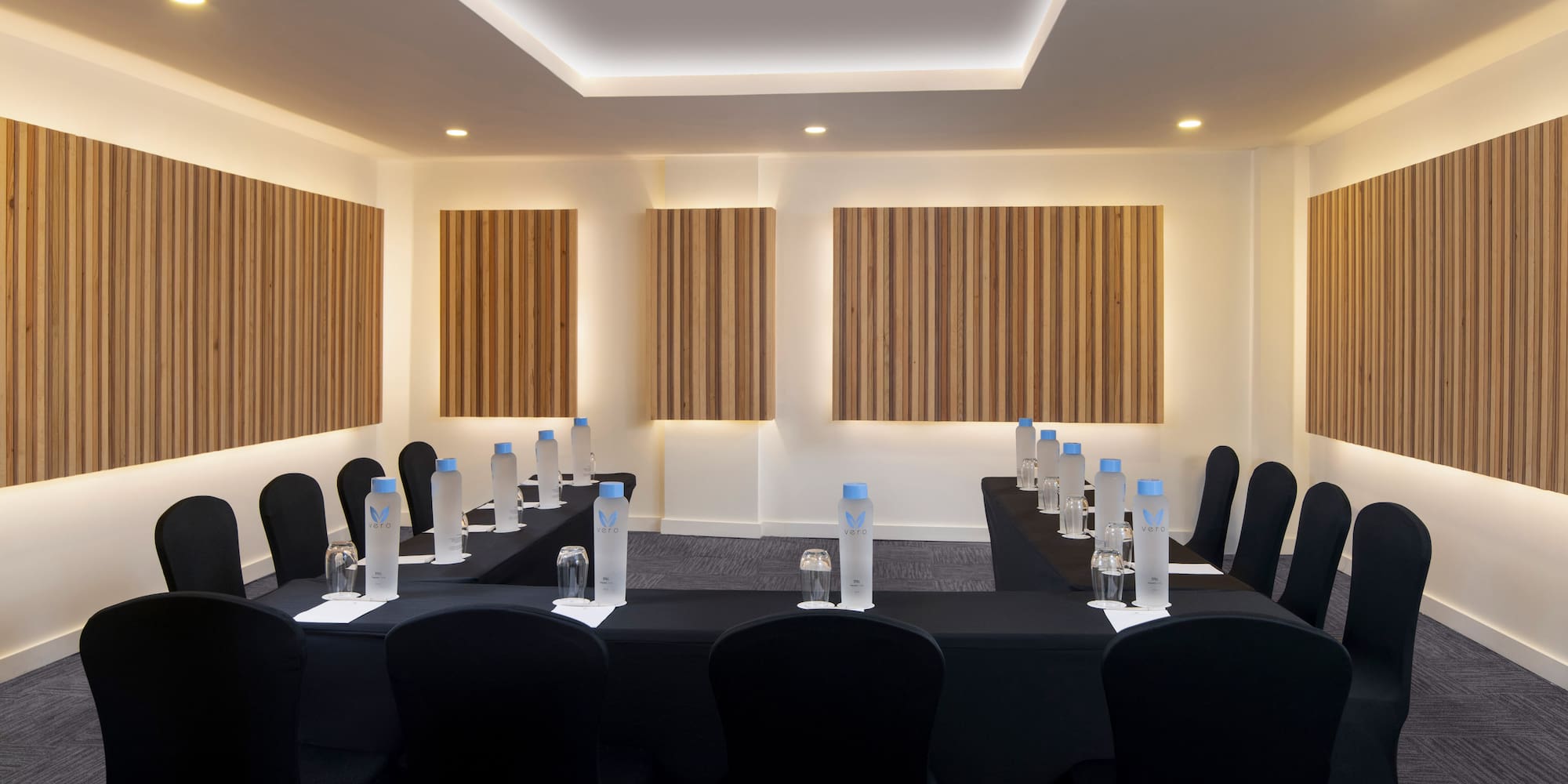 a room with black chairs and black tablecloths