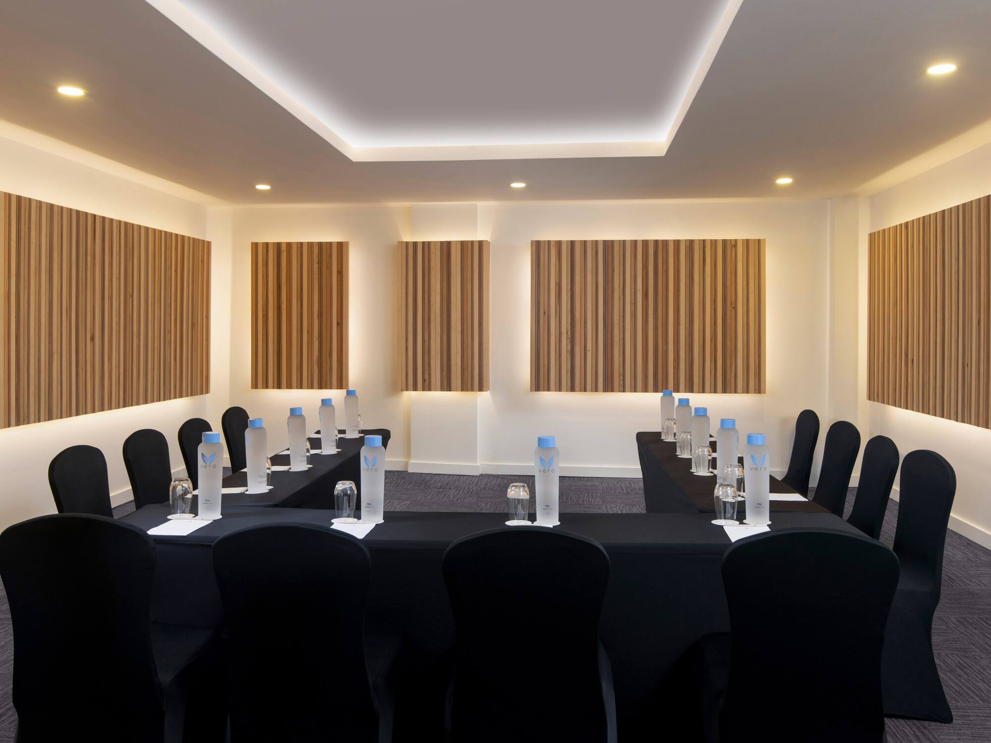 a room with black chairs and black tablecloths